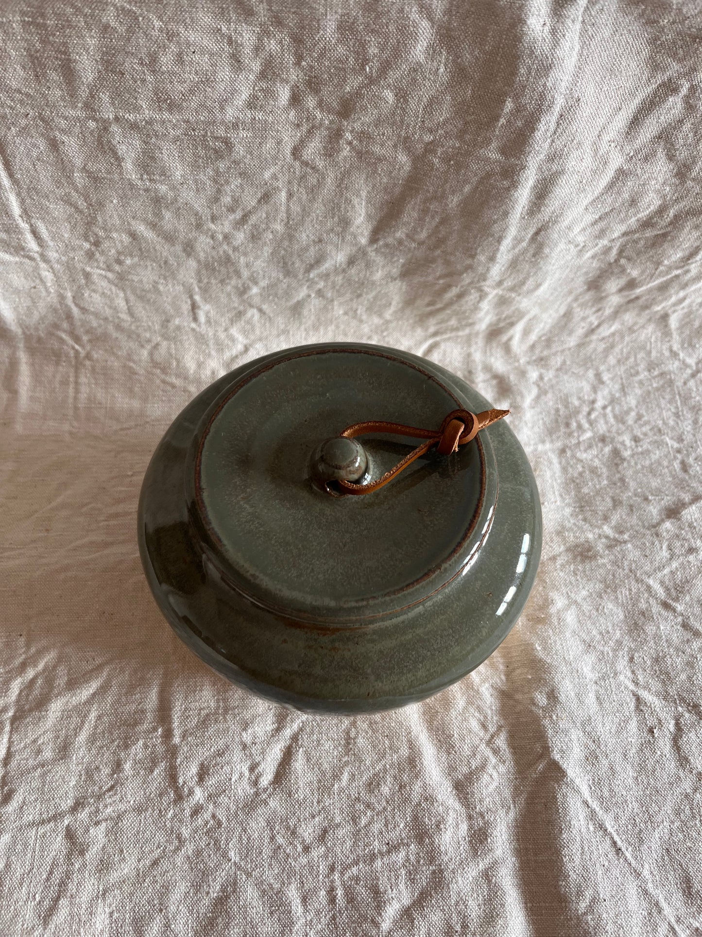 Pot en grès blanc émail vert de gris et lien en cuir