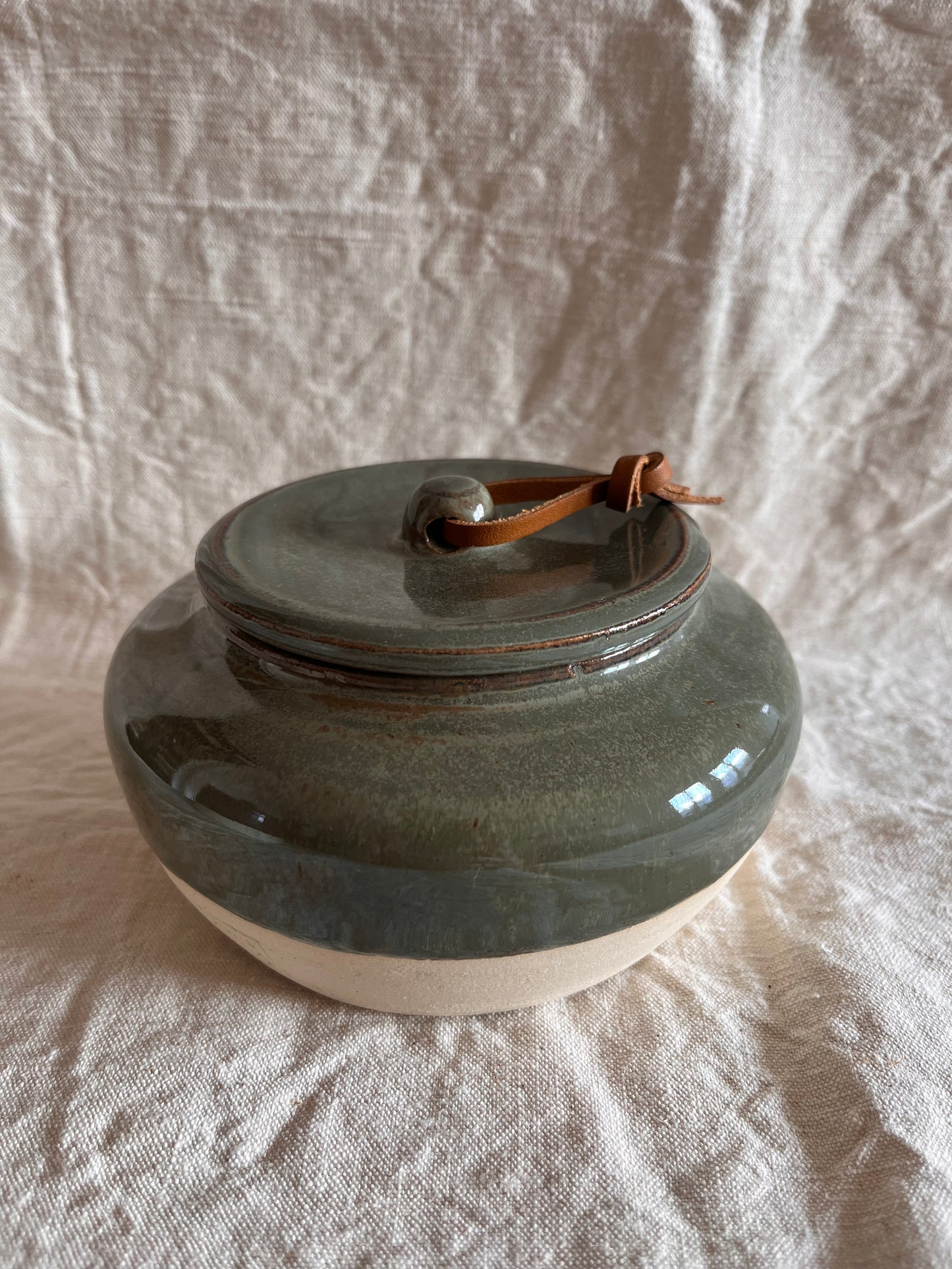 Pot en grès blanc émail vert de gris et lien en cuir